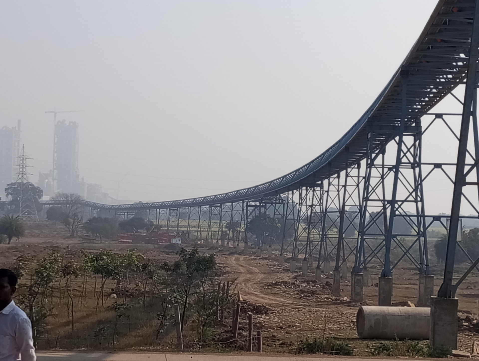 Elevated overland conveyor — Long-span trestle conveyor serving a cement plant.