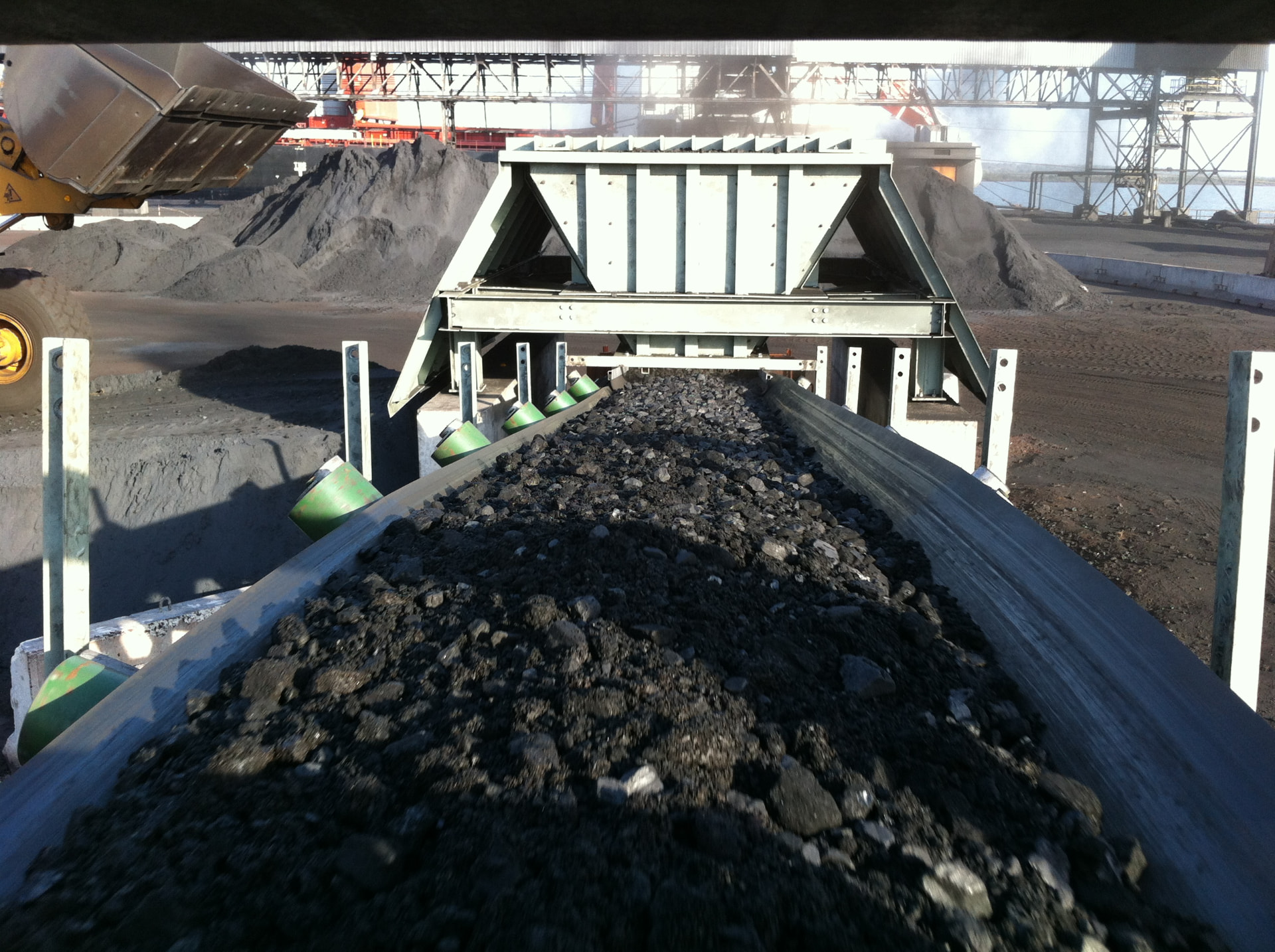 Loaded belt at transfer point — Coal handling belt at a port terminal transfer chute.